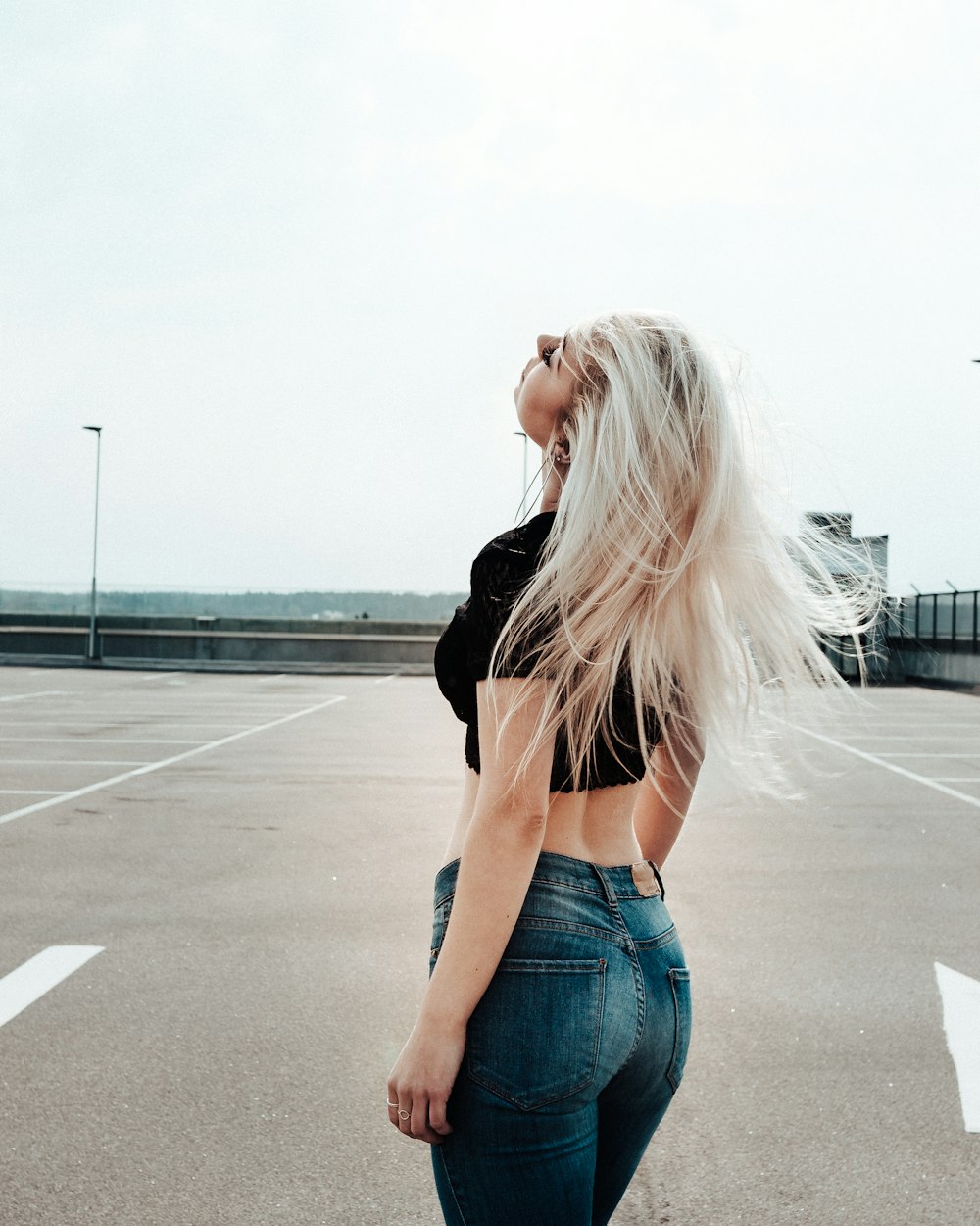 woman wearing black crop top and blue jeans