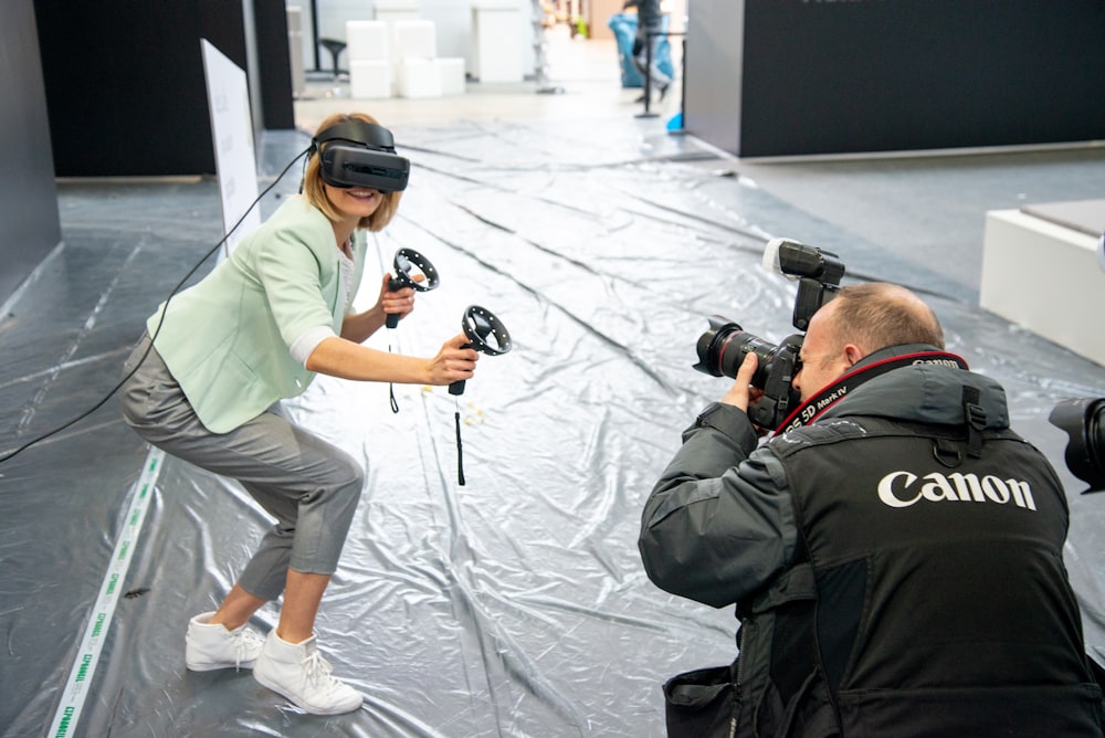 woman wearing virtual reality headset beside man holding camera