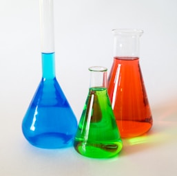 three assorted-color liquid-filled laboratory apparatuses