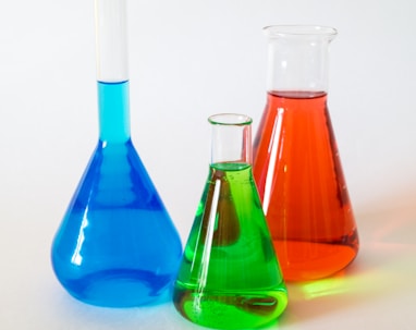 three assorted-color liquid-filled laboratory apparatuses