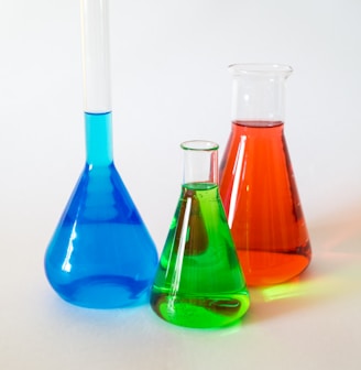 three assorted-color liquid-filled laboratory apparatuses