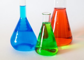 three assorted-color liquid-filled laboratory apparatuses