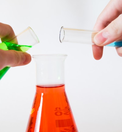 person holding laboratory flasks