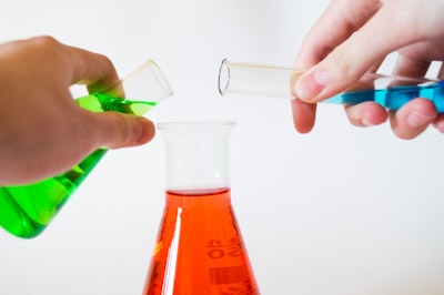 person holding laboratory flasks science teams background