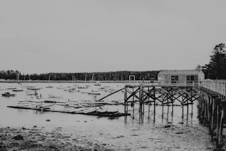 A stylishly matted art print featuring a minimalist sketch of Cape Ann’s harbor boats.