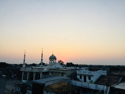 A serene sunset over a historic mosque with intricate architectural details.