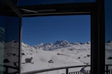 Snow-covered ski slopes visible from the hotel’s large panoramic windows.