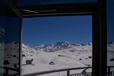 Snow-covered ski slopes visible from the hotel’s large panoramic windows.