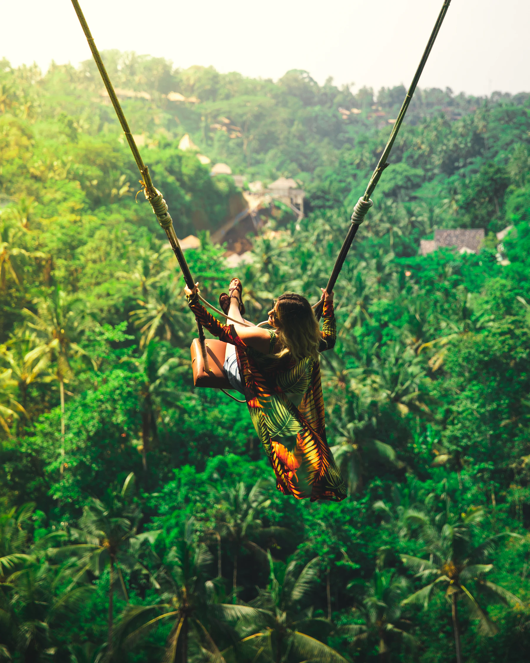 A swing arcing out over dense jungle