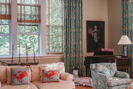 Cozy living room with beach-themed decor and natural sunlight streaming through large windows.