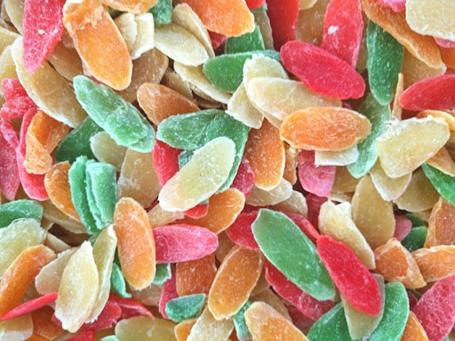 Close-up of colorful dehydrated fruit and vegetable slices arranged on a wooden table.