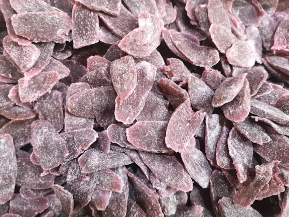 Vibrant close-up of freeze-dried fruit pieces glowing with neon purple and pink hues