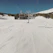 A skier carving fresh tracks down a pristine, snow-covered mountain slope under a clear blue sky.