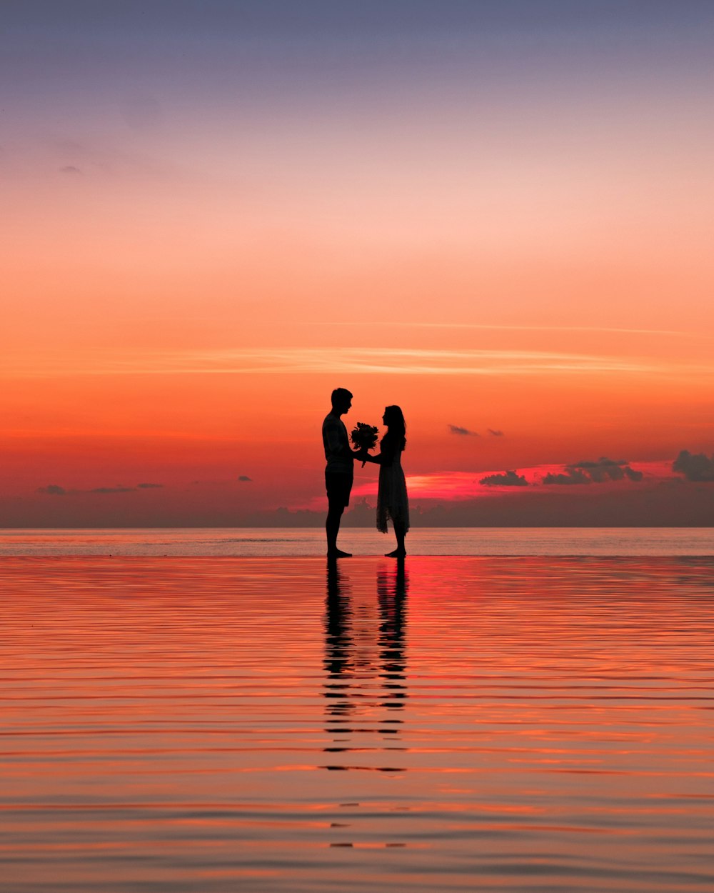 man and woman silhouette against golden hour