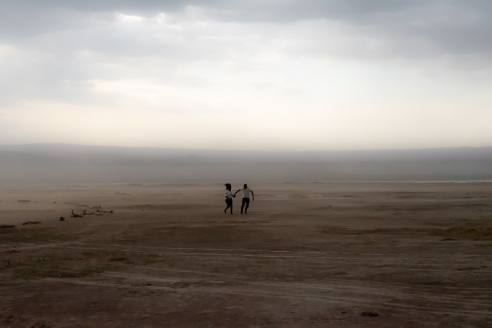 two persons standing on open field