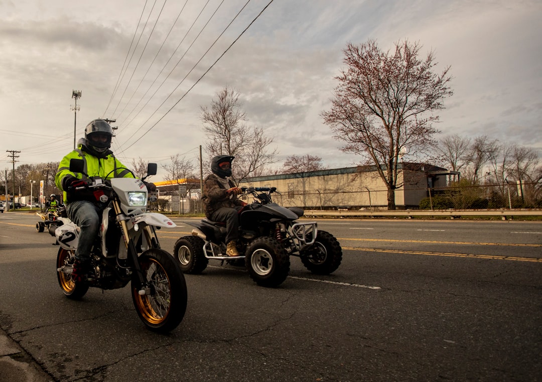 two persons driving motorcycle and ATV