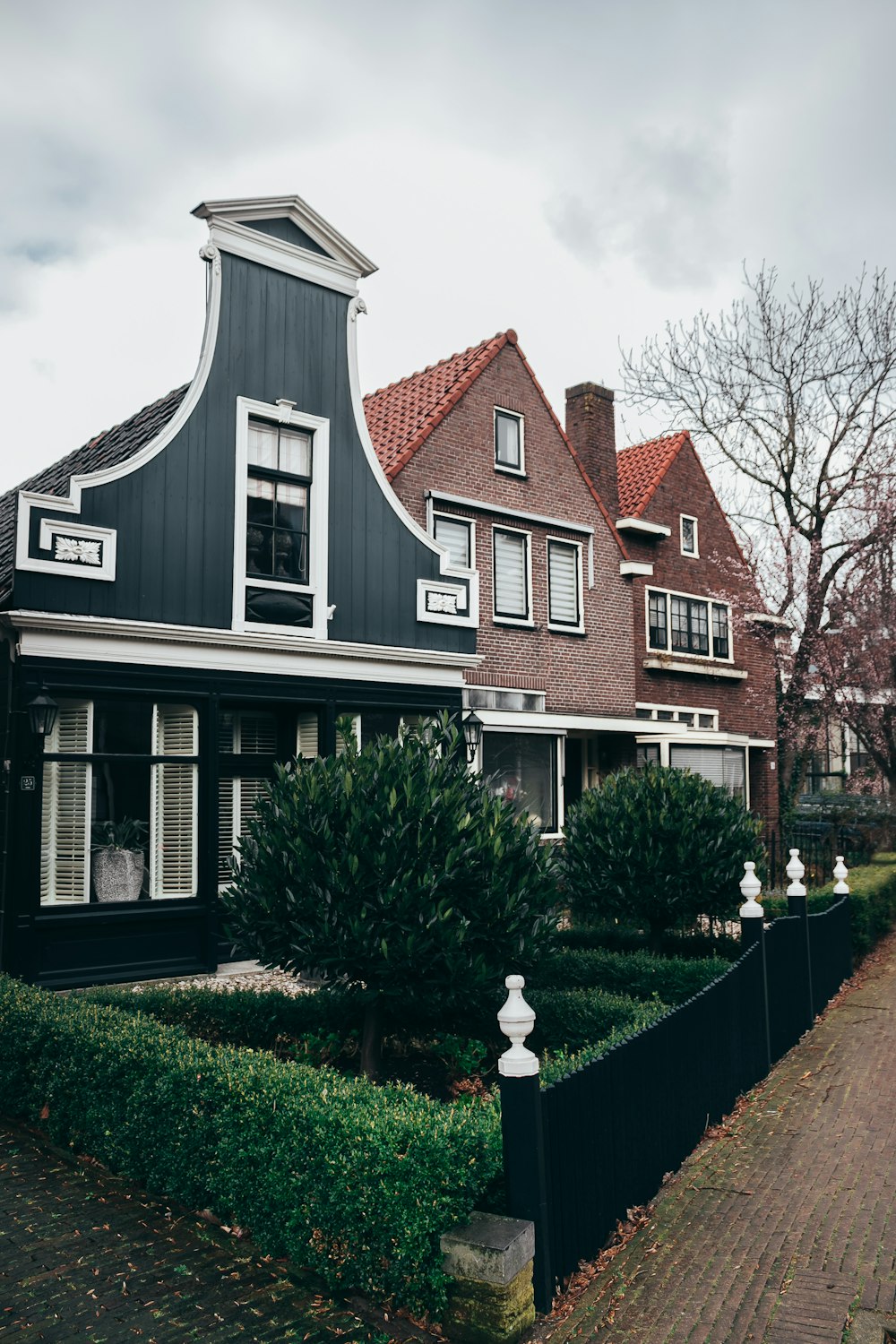 three wooden brown, white and green houses