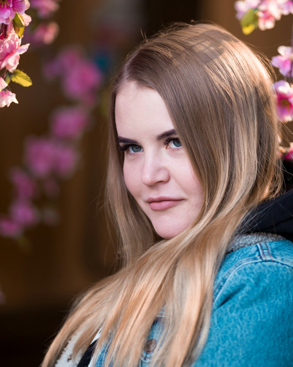 woman surrounded by pink cherry blossom flowers