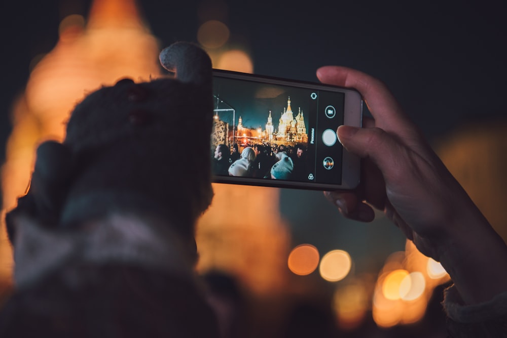 person taking picture of a building on it smartphone