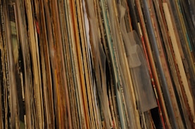 A close-up of vinyl records stacked on a table.