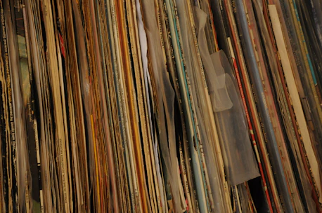 Close-up of colorful 1970s vinyl records stacked on a wooden shelf