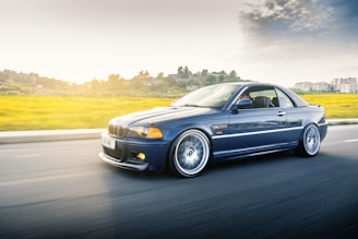 Dynamic shot of a sporty blue Nissan Z speeding along a coastal road.
