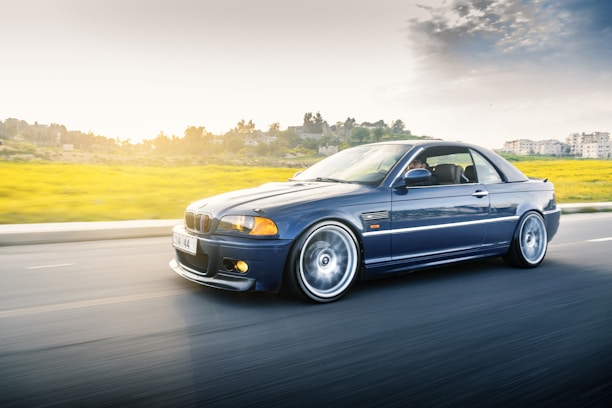 Dynamic shot of a sporty blue Nissan Z speeding along a coastal road.