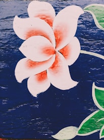 A stylized white and red flower with large petals is painted on a dark blue textured background. Green leaves accompany the flower, adding contrast and depth to the artwork.