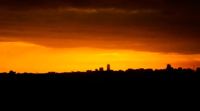 A vibrant megaphone emitting sound waves over a city skyline at sunset.