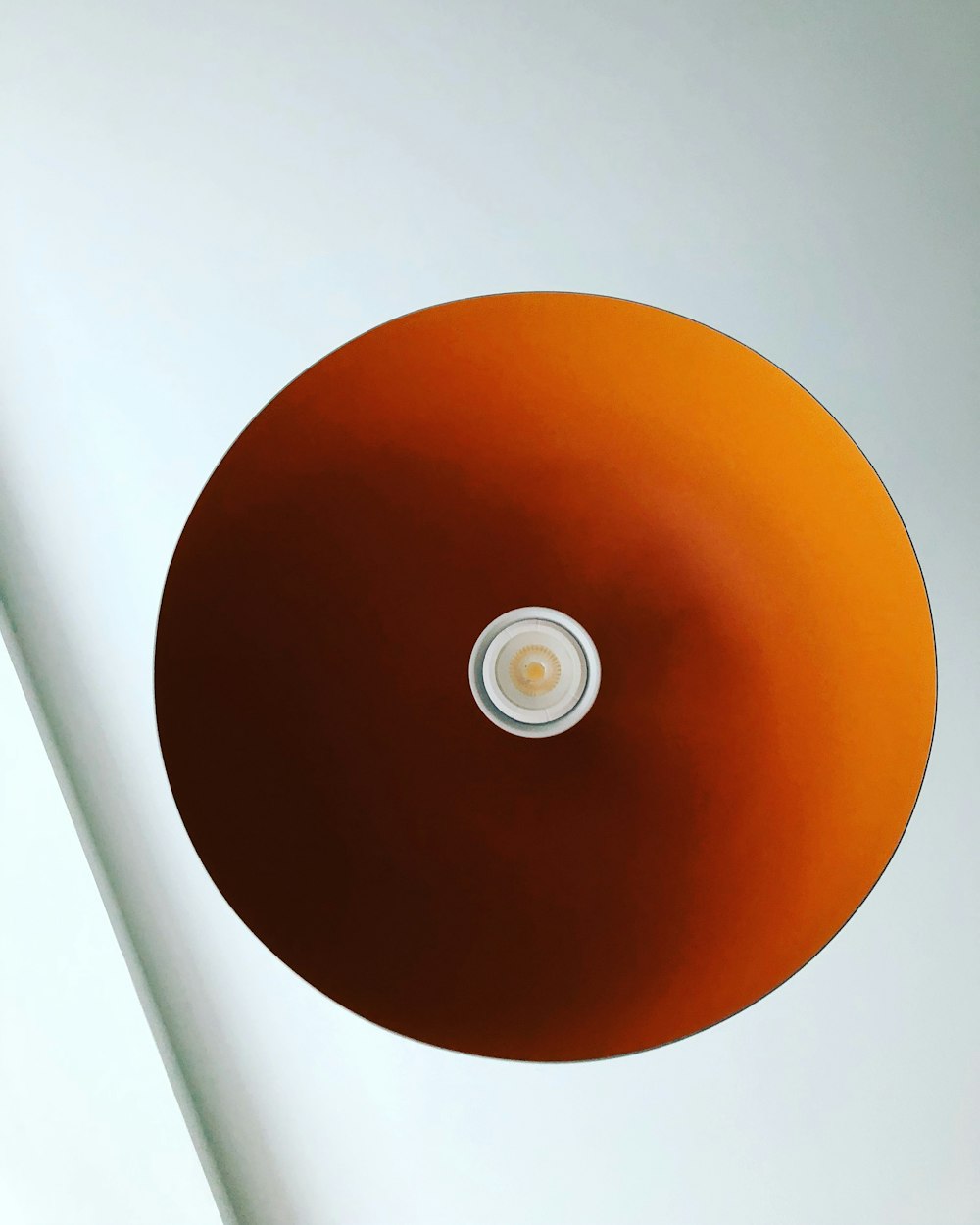 a round light fixture in a white room