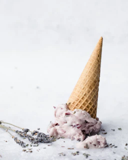 A bright, inviting ice cream cone with fresh fruit toppings on a clean white background.