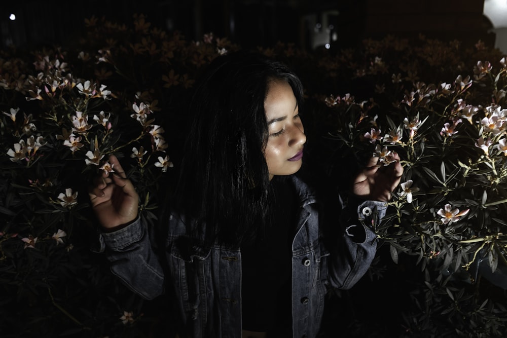 low-light photography of woman in between of white flowers