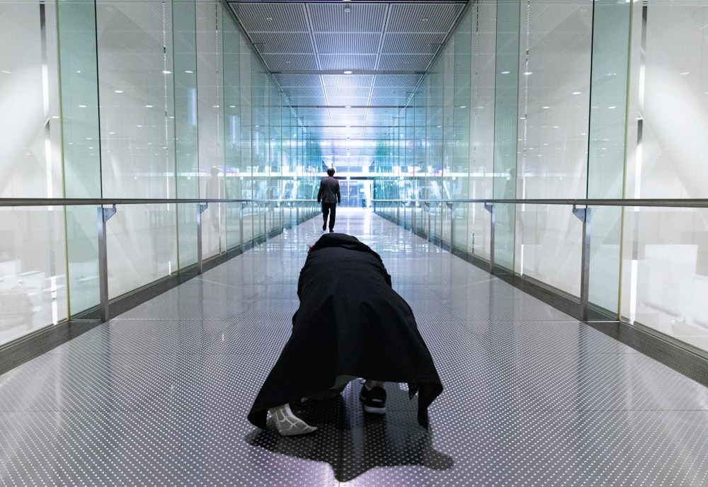 person kneeling on hallway