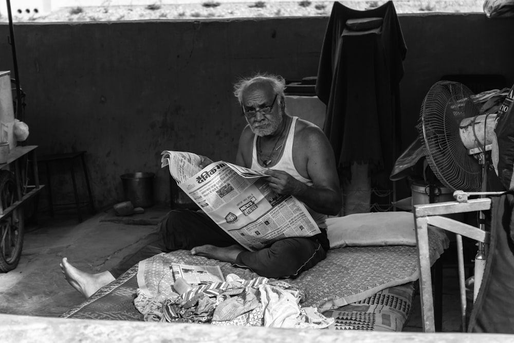 신문을 읽고 있는 남자의 그레이스케일 사진