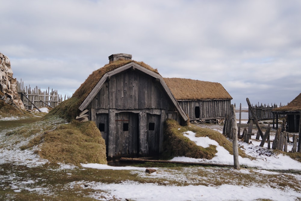 gray wooden house near sea under white skies