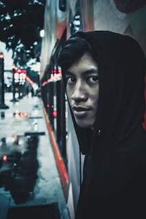 Close-up of a vibrant red hoodie with graffiti-style logo under moody streetlight