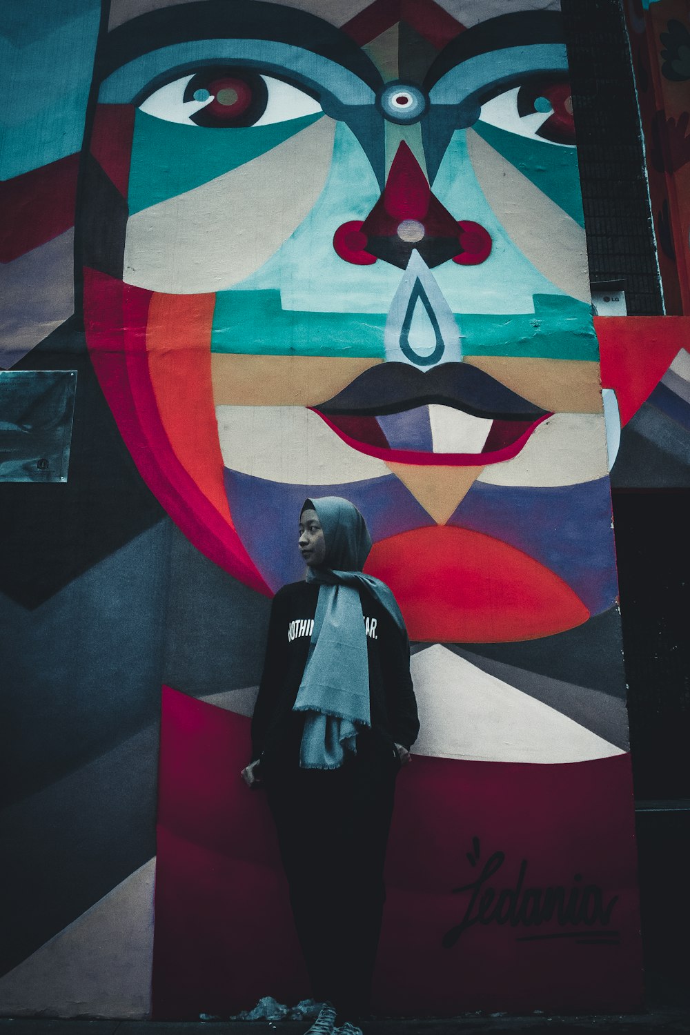 woman wearing hijab and abaya dress standing near wall