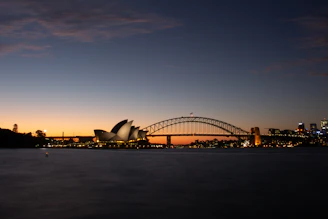 A sleek Sydney skyline at dusk with a subtle overlay of global connection lines.