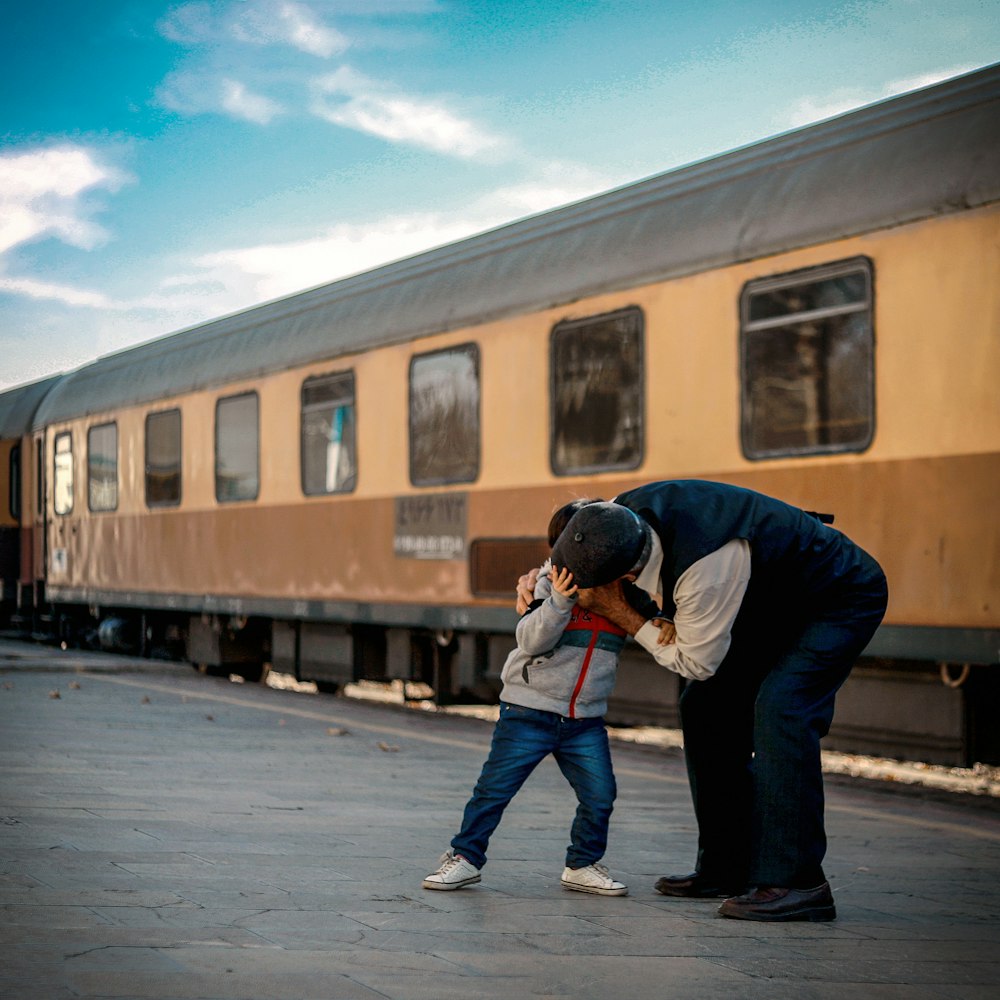 man and boy playing beside train