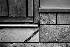 Close-up of textured stone wall blending seamlessly with warm wooden furniture.