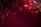 Explosions of vibrant fireworks light up the night sky with bursts of red and sparkling white trails. Smoky clouds create a dramatic backdrop, enhancing the visual spectacle.