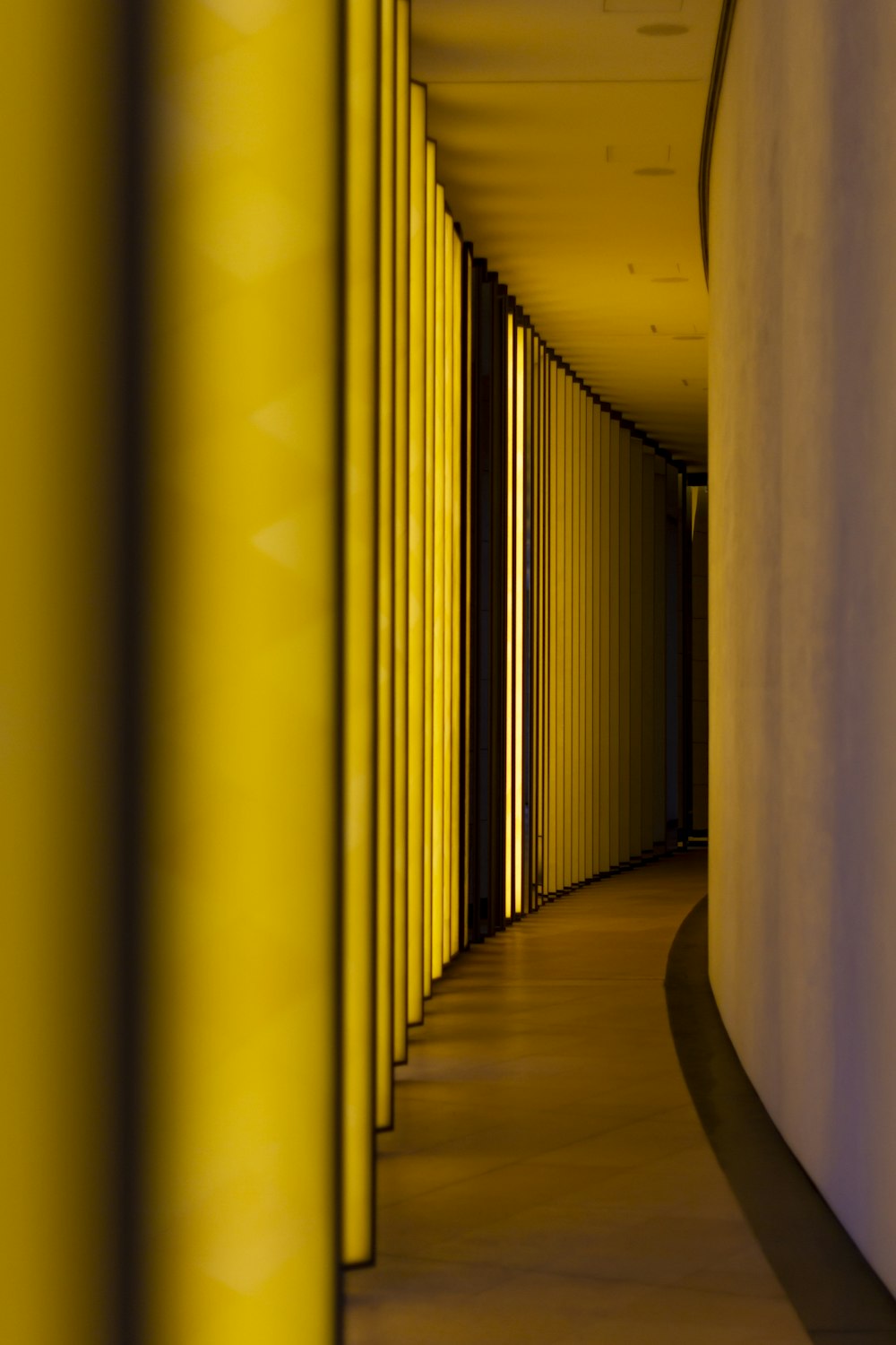 a long hallway with yellow walls and a clock on the wall