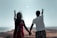 A happy couple exploring a scenic destination with a beautiful landscape in the background.