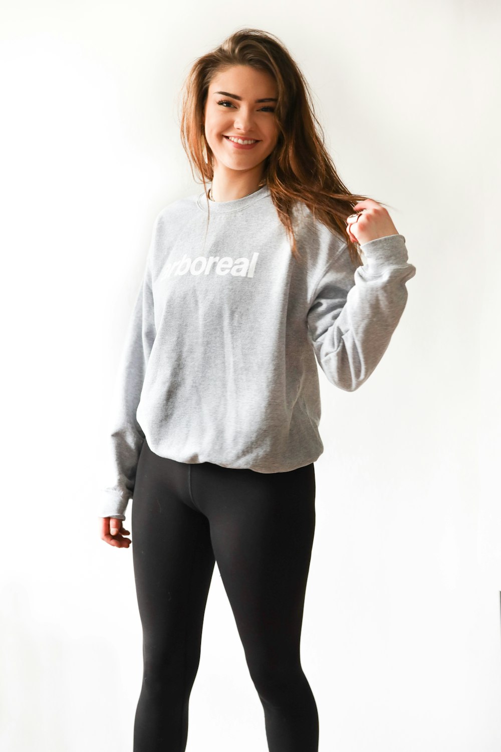 smiling woman wearing gray long-sleeved shirt