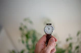 A hand holding a premium watch with a slow-living inspired design.