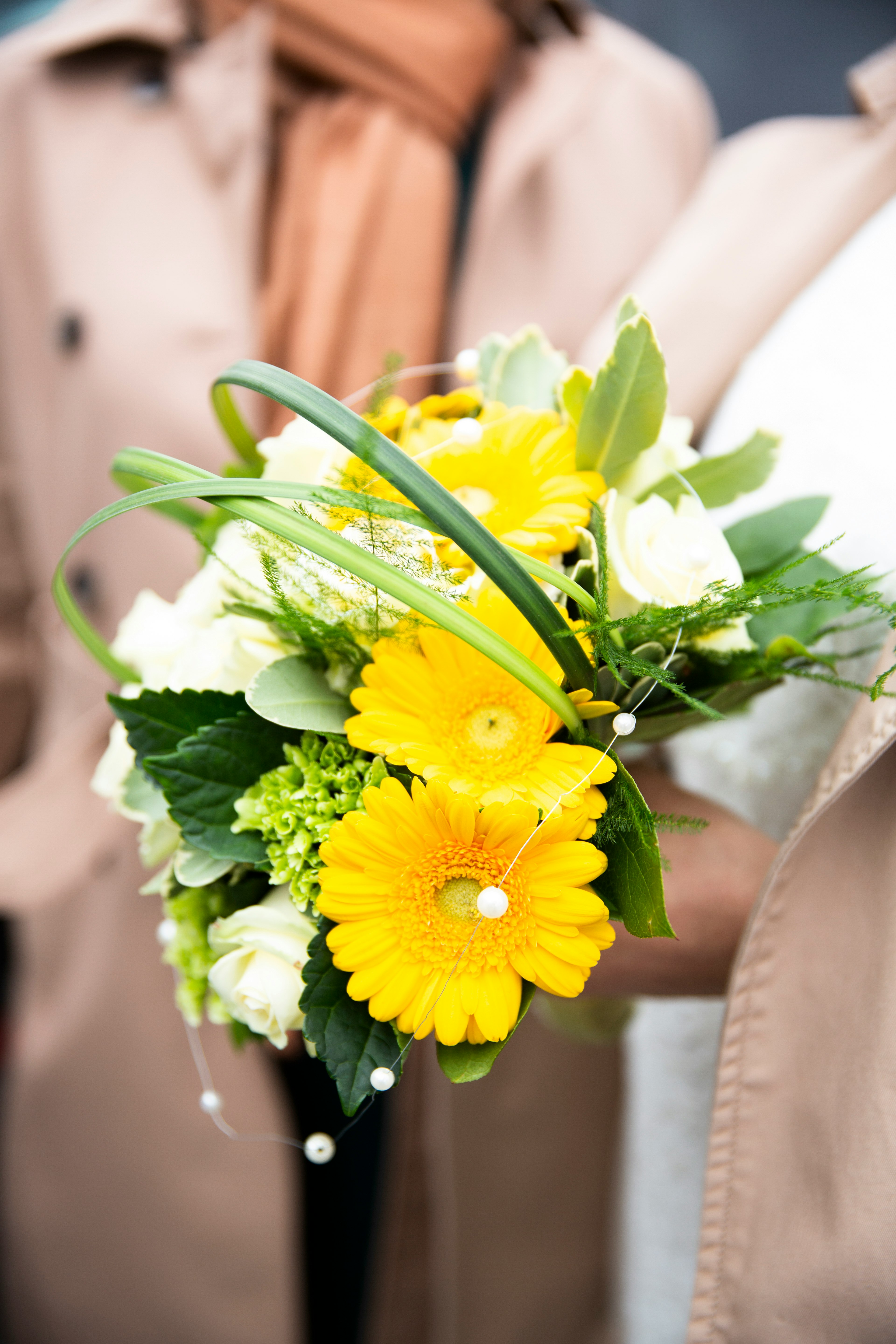 person holding yellow petaled flowers