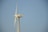A tall wind turbine with three blades is set against a clear blue sky. The equipment is labeled with 'Solon 1250' on the nacelle, which is mounted on a lattice-style tower.