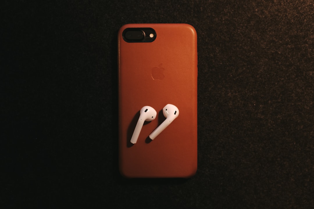 white Apple AirPods on red iPhone