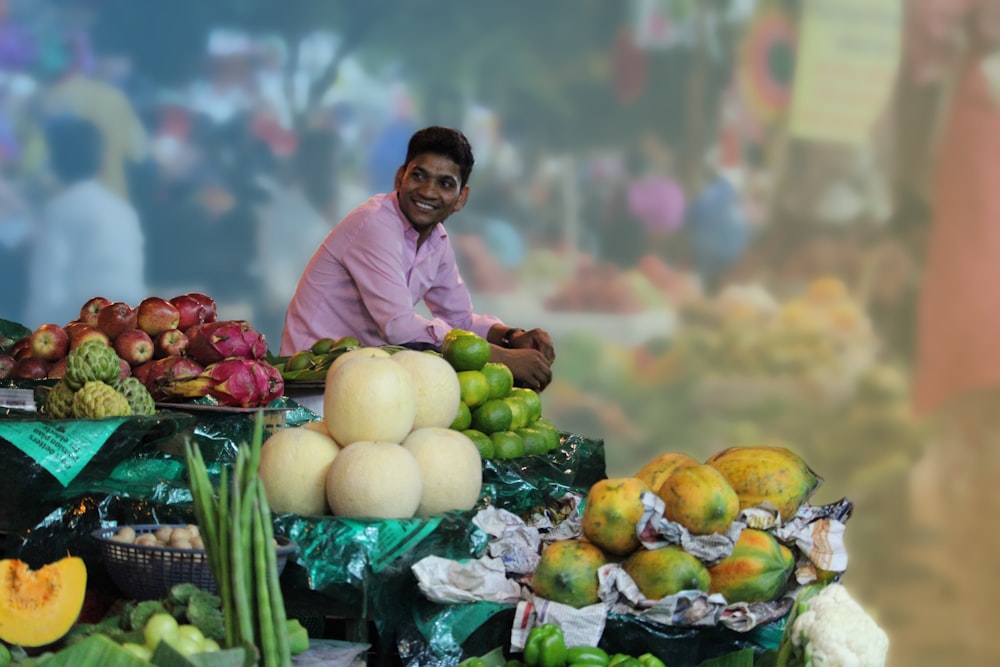 a man sitting at a table full of fruits and vegetables