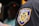 A close-up view of a patch on a uniform, reading 'Taxi and Limousine Commission City of New York' with a yellow and blue emblem showing various figures and symbols.